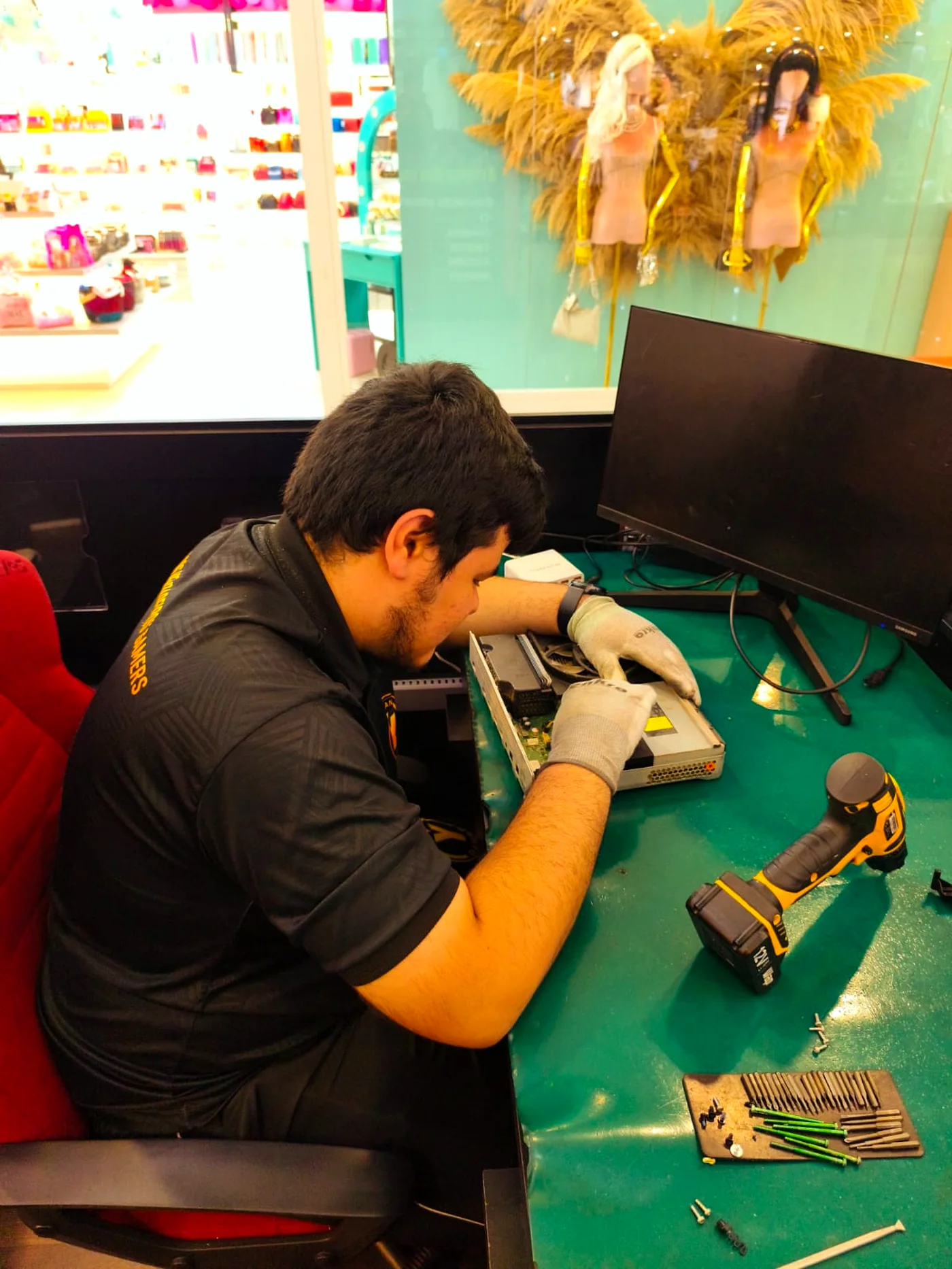 Profissional da CLAN Y GAMER operando equipamento de microsolda na bancada de reparos avançados da matriz em Adrianópolis.