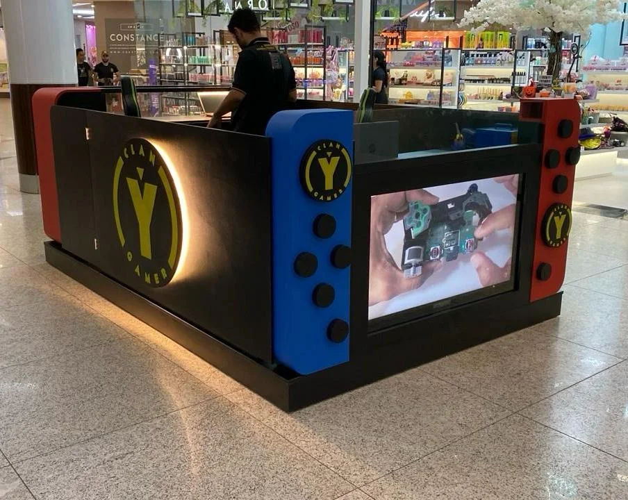 Vista do quiosque CLAN Y GAMER no Shopping Sumaúma realizando atendimento expresso de celulares.